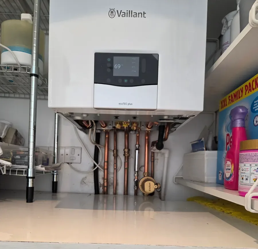 Neat copper pipework running beneath a wall-mounted Vaillant boiler